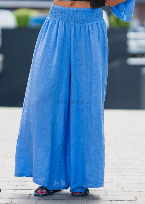 Niebieski komplet lniany damski 100% len składający się z asymetrycznej bluzki oversize oraz szerokich spodni z gumką w pasie. Lekki, przewiewny model idealny do codziennych i eleganckich stylizacji.