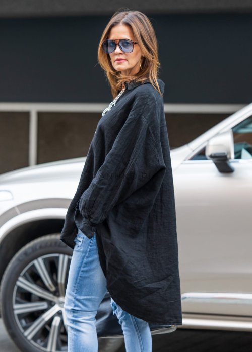 Czarna lniana koszula damska oversize z długim rękawem i kołnierzykiem, stylizowana z jeansami w miejskim looku.