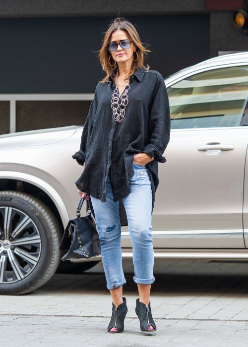 Czarna lniana koszula damska oversize z długim rękawem i kołnierzykiem, stylizowana z jeansami w miejskim looku.