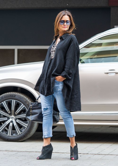 Czarna lniana koszula damska oversize z długim rękawem i kołnierzykiem, stylizowana z jeansami w miejskim looku.