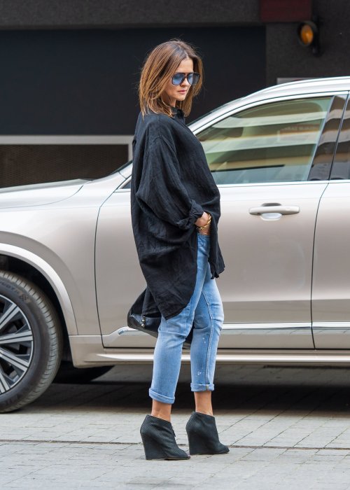Czarna lniana koszula damska oversize z długim rękawem i kołnierzykiem, stylizowana z jeansami w miejskim looku.