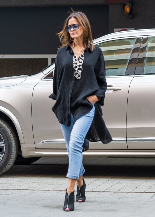 Czarna lniana koszula damska oversize z długim rękawem i kołnierzykiem, stylizowana z jeansami w miejskim looku.