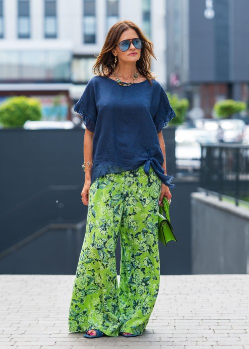 Granatowa lniana bluzka damska z dodatkiem jedwabiu, falbaniastymi rękawami oraz asymetrycznym wykończeniem z ozdobnym wiązaniem. Elegancki model do codziennych stylizacji.