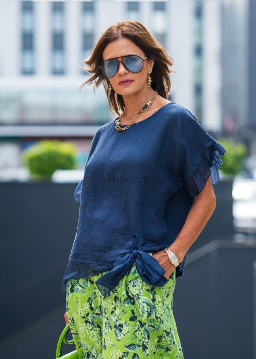 Granatowa lniana bluzka damska z dodatkiem jedwabiu, falbaniastymi rękawami oraz asymetrycznym wykończeniem z ozdobnym wiązaniem. Elegancki model do codziennych stylizacji.