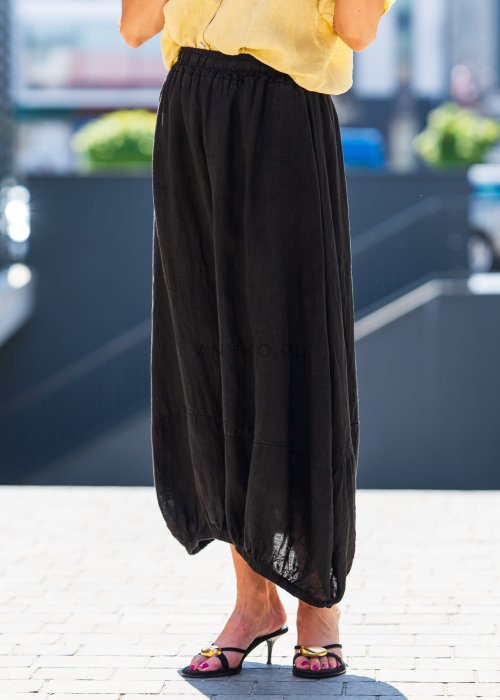 Czarna spódnica lniana maxi z gumką w pasie i marszczonym dołem, o luźnym fasonie. Stylizacja z żółtą koszulą i eleganckimi klapkami na obcasie.