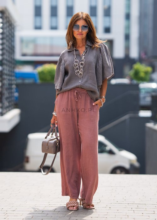 Szara koszula lniana damska o luźnym kroju z szerokimi rękawami, zestawiona z różowymi spodniami w lekkiej, miejskiej stylizacji.