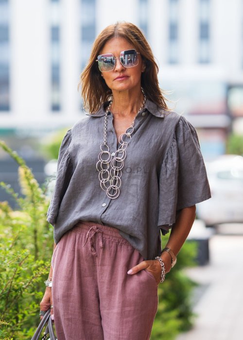 Szara koszula lniana damska o luźnym kroju z szerokimi rękawami, zestawiona z różowymi spodniami w lekkiej, miejskiej stylizacji.
