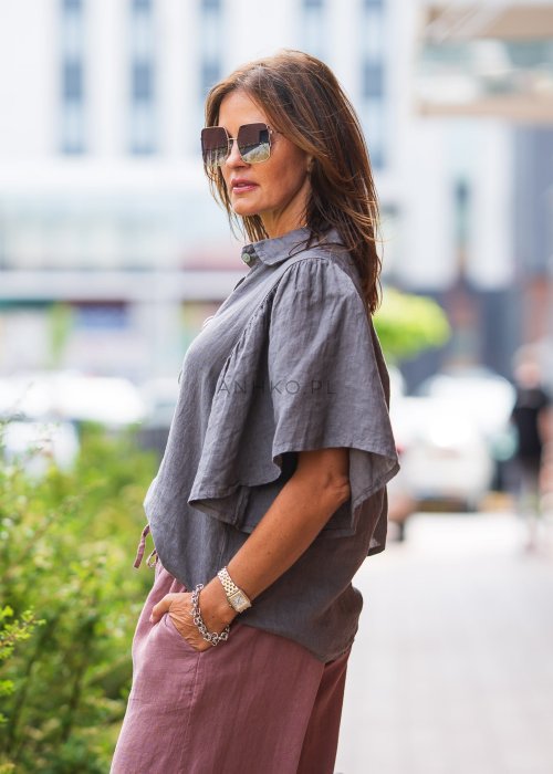 Szara koszula lniana damska o luźnym kroju z szerokimi rękawami, zestawiona z różowymi spodniami w lekkiej, miejskiej stylizacji.