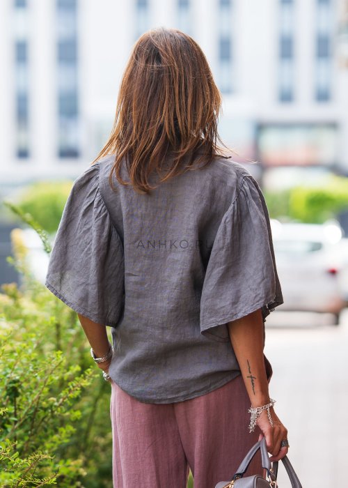 Szara koszula lniana damska o luźnym kroju z szerokimi rękawami, zestawiona z różowymi spodniami w lekkiej, miejskiej stylizacji.