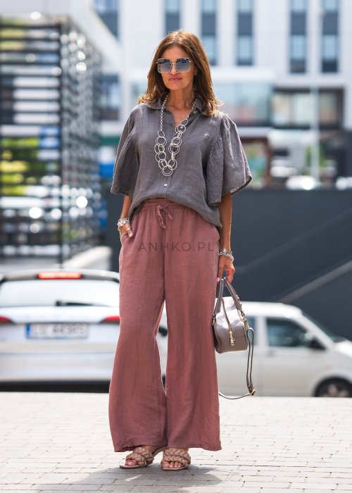 Szara koszula lniana damska o luźnym kroju z szerokimi rękawami, zestawiona z różowymi spodniami w lekkiej, miejskiej stylizacji.
