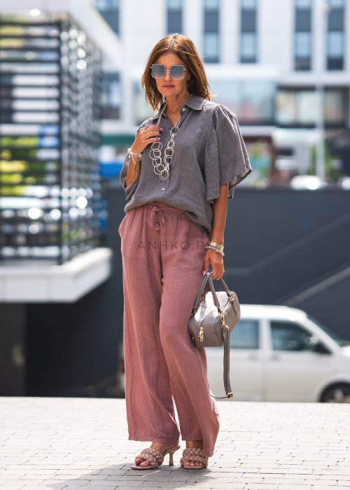Szara koszula lniana damska o luźnym kroju z szerokimi rękawami, zestawiona z różowymi spodniami w lekkiej, miejskiej stylizacji.