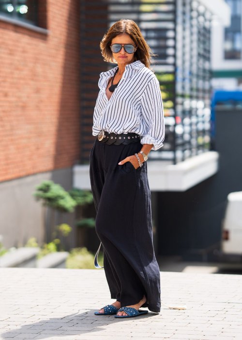 Lniana koszula damska biała w granatowe paski, luźny fason z kołnierzykiem i guzikami, stylizacja z czarną spódnicą i paskiem.