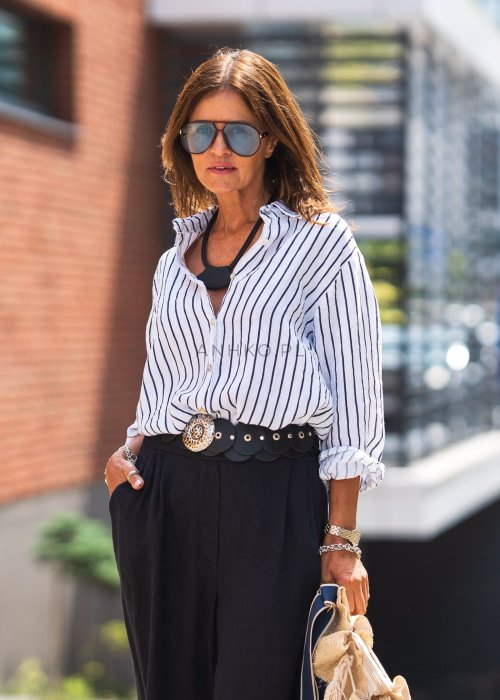 Lniana koszula damska biała w granatowe paski, luźny fason z kołnierzykiem i guzikami, stylizacja z czarną spódnicą i paskiem.