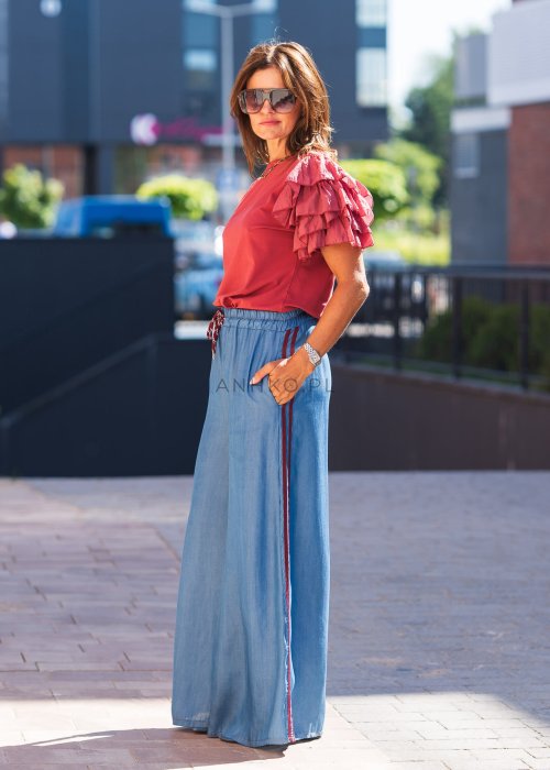 Niebieskie spodnie z lekkiego denimu o szerokich nogawkach, elastycznym pasie i ozdobnych lampasach w kolorze bordo
