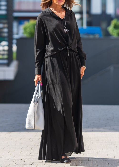 Czarny komplet z lekkiej, przewiewnej tkaniny – bluza z kapturem i wiązaniem w talii oraz długa, swobodna spódnica. Elegancja i wygoda w jednym.