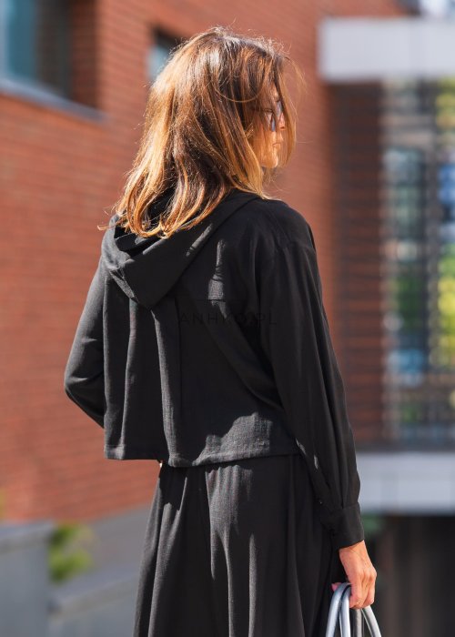 Czarny komplet z lekkiej, przewiewnej tkaniny – bluza z kapturem i wiązaniem w talii oraz długa, swobodna spódnica. Elegancja i wygoda w jednym.