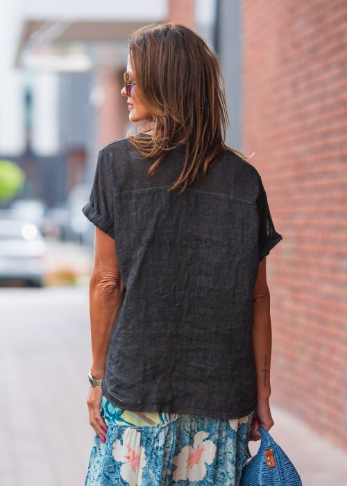 Antracytowa lniana bluzka damska o luźnym kroju z krótkim rękawem i delikatnym dekoltem. Naturalny materiał miękko układa się na sylwetce.