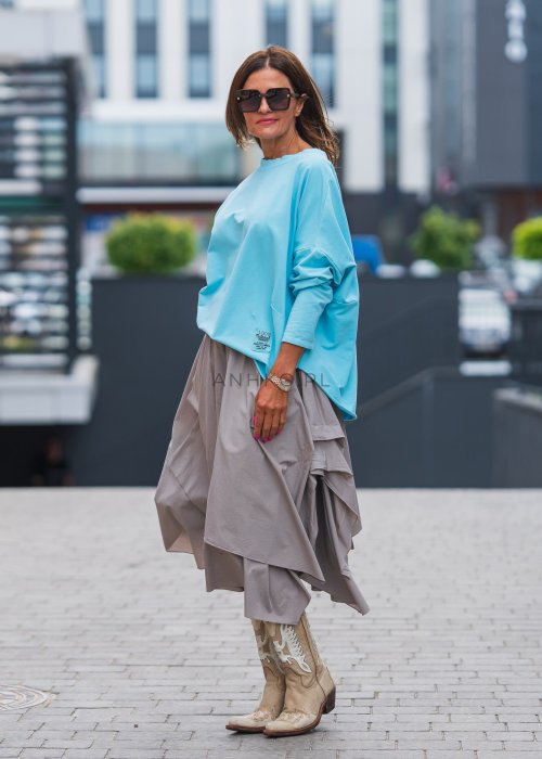 Bluza damska oversize w kolorze baby blue z długim rękawem i naszywką na froncie. Luźny fason w stylizacji z szeroką spódnicą i dodatkami w miejskim stylu.