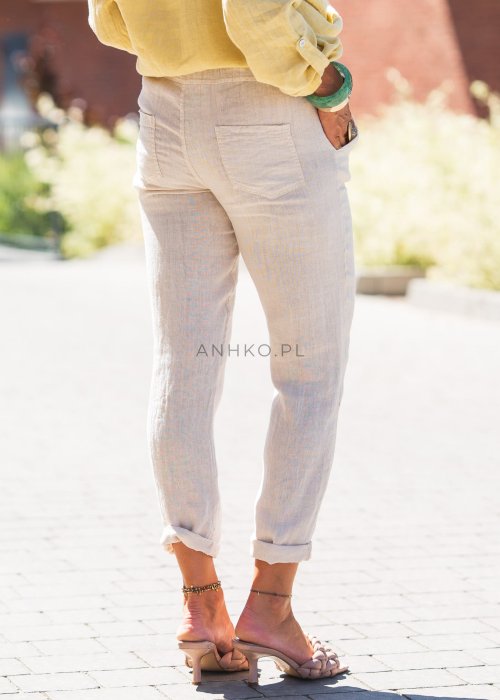 Jasne lniane spodnie damskie o zwężanym kroju, z elastyczną talią i troczkiem, w lekkim, letnim stylu casual