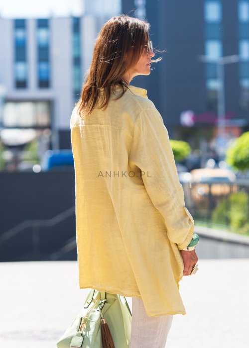 Żółta lniana koszula oversize z długim rękawem i kołnierzykiem, zapinana na guziki, w zestawie z jasnymi spodniami w stylu letnim