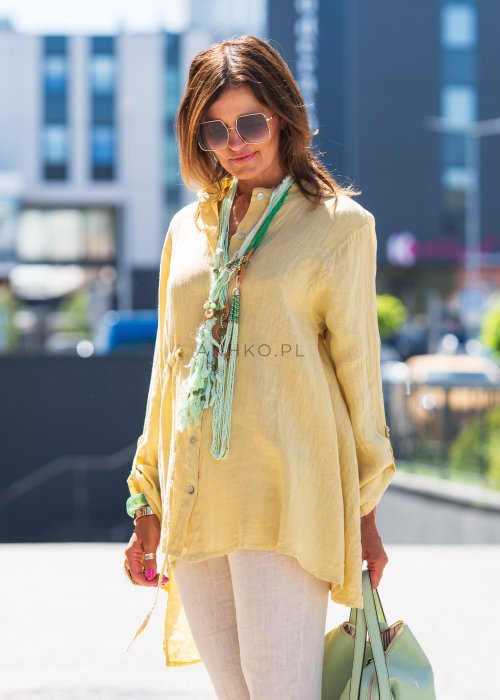 Żółta lniana koszula oversize z długim rękawem i kołnierzykiem, zapinana na guziki, w zestawie z jasnymi spodniami w stylu letnim