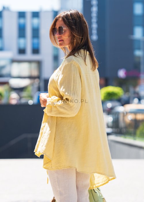 Żółta lniana koszula oversize z długim rękawem i kołnierzykiem, zapinana na guziki, w zestawie z jasnymi spodniami w stylu letnim