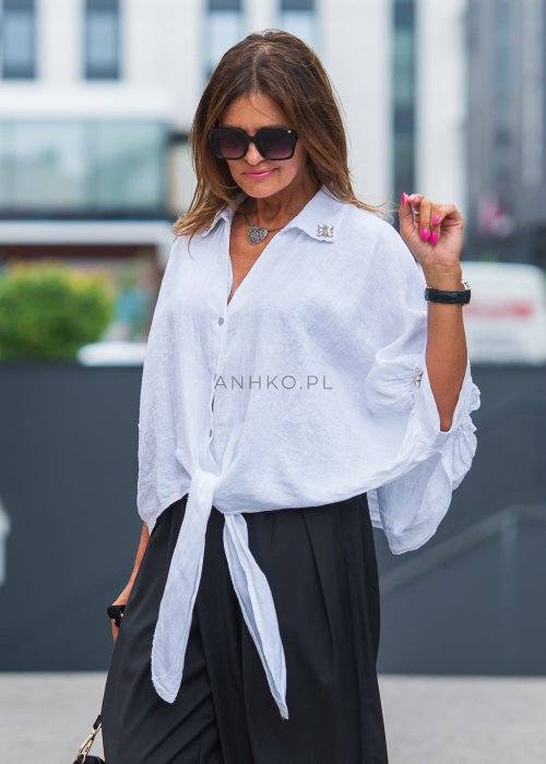 Biała lniana koszula oversize z kołnierzykiem, ozdobnymi guzikami i wiązaniem z przodu, w zestawie z czarnymi spodniami