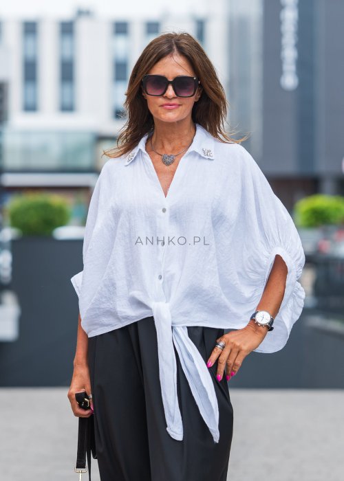 Biała lniana koszula oversize z kołnierzykiem, ozdobnymi guzikami i wiązaniem z przodu, w zestawie z czarnymi spodniami