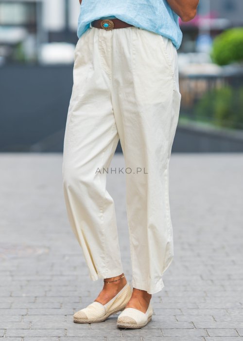 Jasnokremowe, luźne spodnie o prostym kroju, wykonane z lekkiego i przewiewnego materiału, z wygodną gumką w pasie i kieszeniami po bokach – idealne do letnich, swobodnych stylizacji.