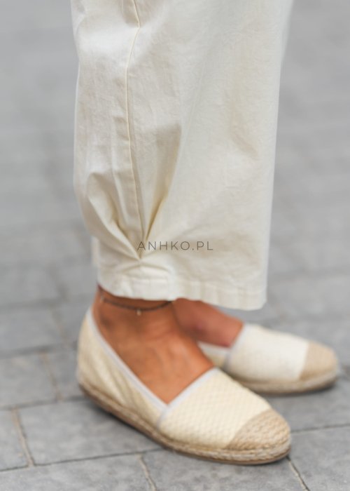 Jasnokremowe, luźne spodnie o prostym kroju, wykonane z lekkiego i przewiewnego materiału, z wygodną gumką w pasie i kieszeniami po bokach – idealne do letnich, swobodnych stylizacji.