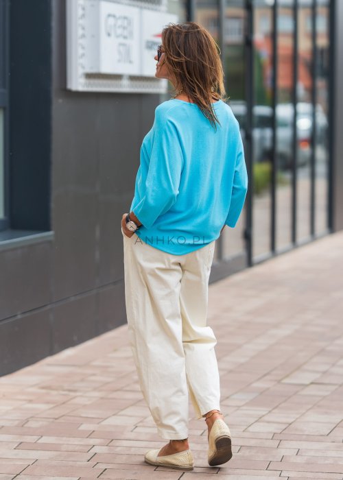 Jasnokremowe, luźne spodnie o prostym kroju, wykonane z lekkiego i przewiewnego materiału, z wygodną gumką w pasie i kieszeniami po bokach – idealne do letnich, swobodnych stylizacji.