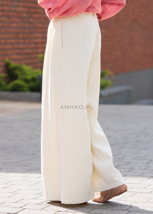 Kremowe szerokie spodnie damskie z wysokim stanem, zakładkami i kieszeniami, wykonane z lekkiego, przewiewnego materiału