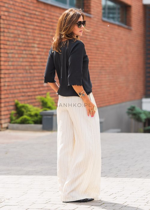 Jasne, szerokie spodnie damskie w pionowe paski, z lekkiego materiału, o luźnym, przewiewnym kroju idealnym na lato