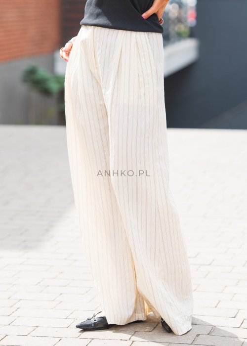 Jasne, szerokie spodnie damskie w pionowe paski, z lekkiego materiału, o luźnym, przewiewnym kroju idealnym na lato