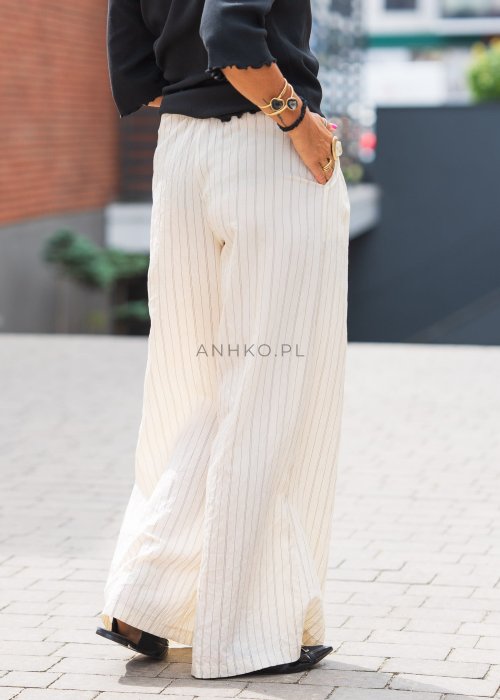 Jasne, szerokie spodnie damskie w pionowe paski, z lekkiego materiału, o luźnym, przewiewnym kroju idealnym na lato