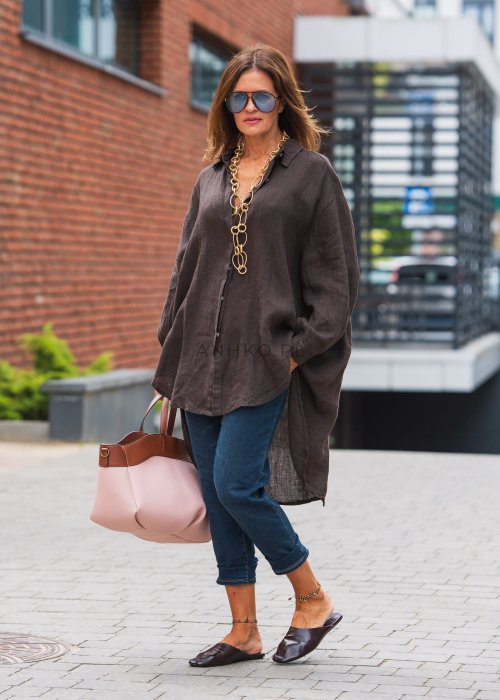 Czekoladowa lniana koszula damska oversize z długim rękawem i wydłużonym tyłem, stylizowana z jeansami w miejskim stylu.
