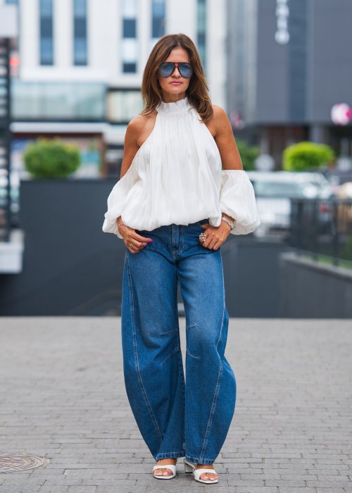 Biała, elegancka bluzka bez ramion z szerokimi rękawami i stójką.