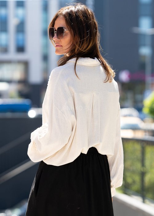 Jasnobeżowa koszula z ażurowymi wstawkami i długim rękawem.