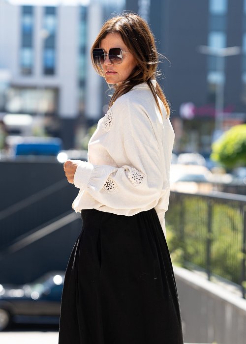 Jasnobeżowa koszula z ażurowymi wstawkami i długim rękawem.