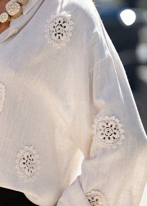 Jasnobeżowa koszula z ażurowymi wstawkami i długim rękawem.