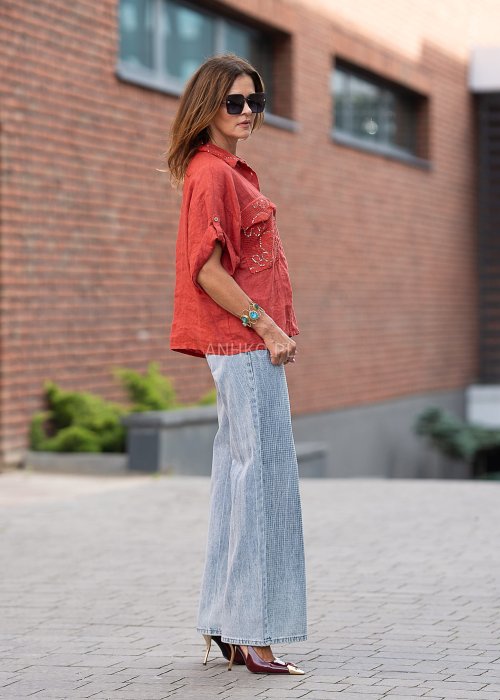 Lniana koszula w intensywnym odcieniu czerwieni z haftowanymi, ażurowymi kieszeniami i podwijanymi rękawami. Lekka, przewiewna i stylowa.