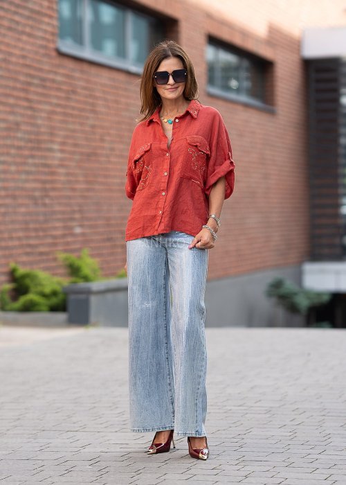 Lniana koszula w intensywnym odcieniu czerwieni z haftowanymi, ażurowymi kieszeniami i podwijanymi rękawami. Lekka, przewiewna i stylowa.