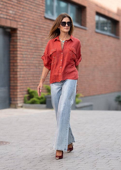 Lniana koszula w intensywnym odcieniu czerwieni z haftowanymi, ażurowymi kieszeniami i podwijanymi rękawami. Lekka, przewiewna i stylowa.