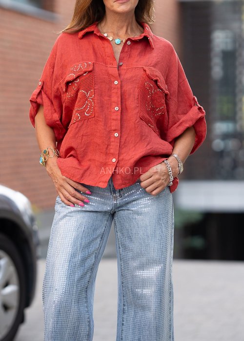 Lniana koszula w intensywnym odcieniu czerwieni z haftowanymi, ażurowymi kieszeniami i podwijanymi rękawami. Lekka, przewiewna i stylowa.