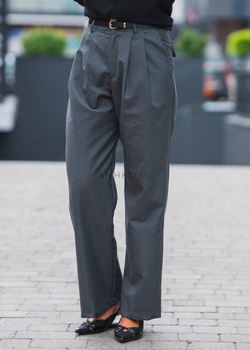 Szare, eleganckie spodnie z wysokim stanem i zakładkami z przodu, uzupełnione czarnym paskiem, zestawione z czarnymi, lakierowanymi mokasynami.