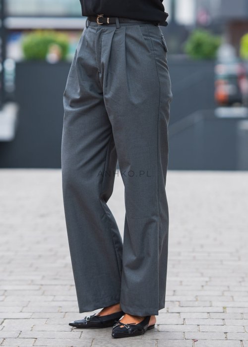 Szare, eleganckie spodnie z wysokim stanem i zakładkami z przodu, uzupełnione czarnym paskiem, zestawione z czarnymi, lakierowanymi mokasynami.