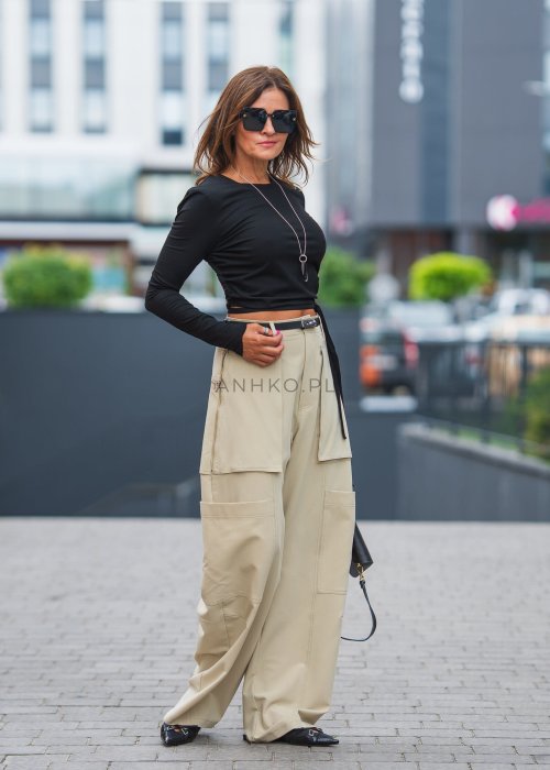 Czarny crop top z odkrytymi plecami i wiązaniem, zestawiony z beżowymi spodniami cargo, tworzy odważny, miejski look.