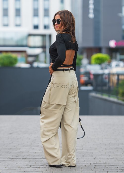 Czarny crop top z odkrytymi plecami i wiązaniem, zestawiony z beżowymi spodniami cargo, tworzy odważny, miejski look.
