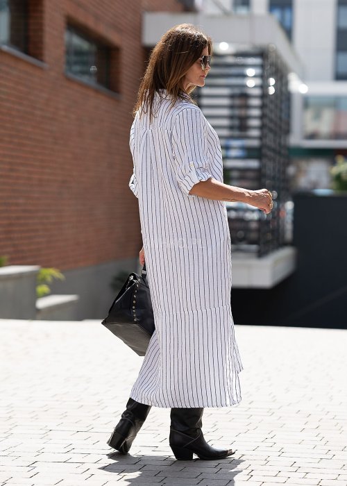 Lniana sukienka koszulowa w biało-czarny prążek, długi luźny fason z guzikami i rozcięciami, stylizacja miejska z kozakami.