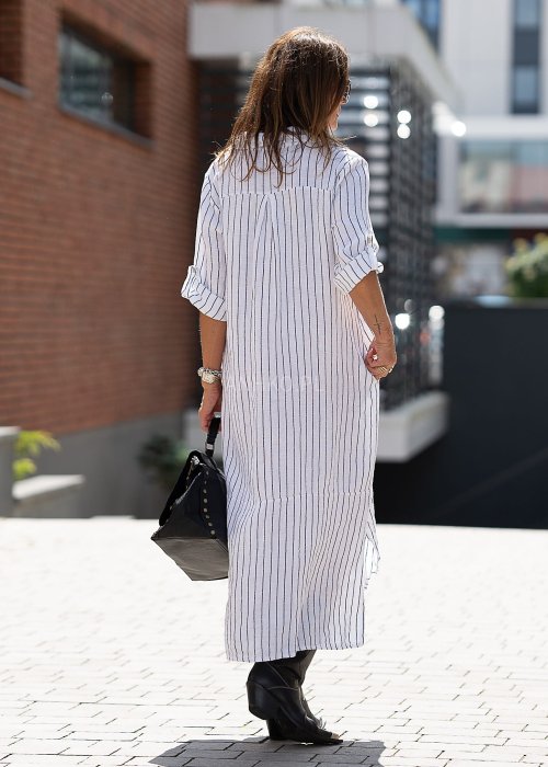 Lniana sukienka koszulowa w biało-czarny prążek, długi luźny fason z guzikami i rozcięciami, stylizacja miejska z kozakami.